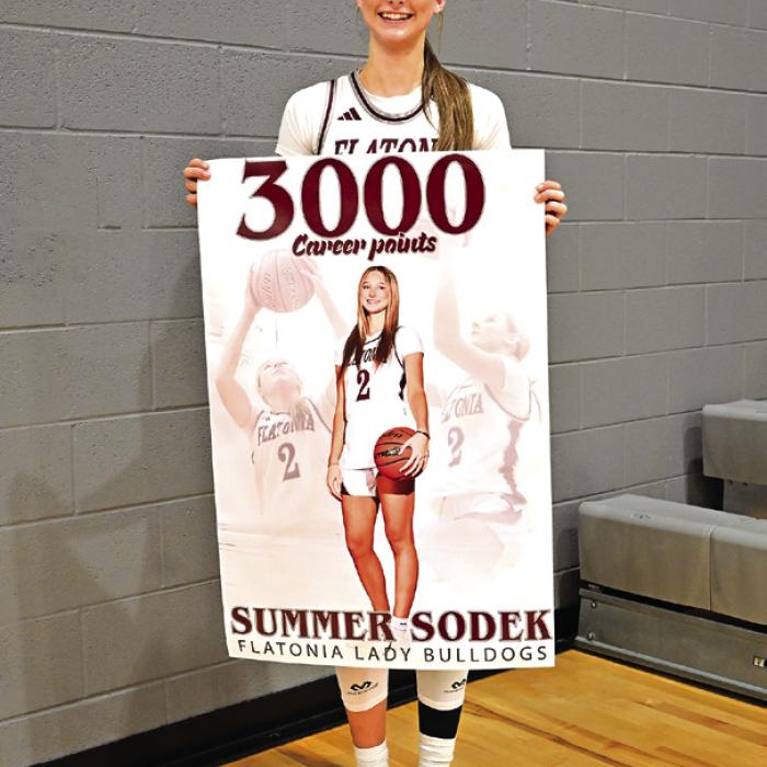 Flatonia’s Summer Sodek holds up a banner after Tuesday’s game to celebrate scoring 3,000 career points. Photo by Stephanie Steinhauser