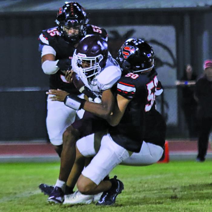 Schulenburg’s Dean Bradley (#55) and Jayden Olmos (#50) bring down Flatonia quarterback Jaylon Anderson Friday. Photo by Audrey Kristynik
