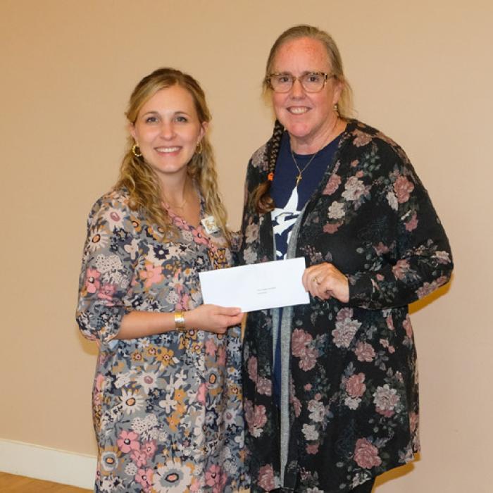 Brittany Siptak, left, presented a grant check to Blinn College Foundation for ACCSS, represented by Susie Shank.