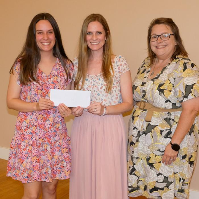 Nicole Davis, left, presented a grant check to Led + Fed, represented by Jenny Neiser and Samantha Niskern.