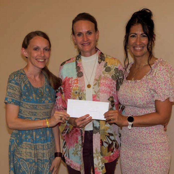 Samantha Wischnewsky, right, presented a grant check to Sacred Heart Catholic School, represented by Katie Janda, left, and Karissa Kleiber, center.