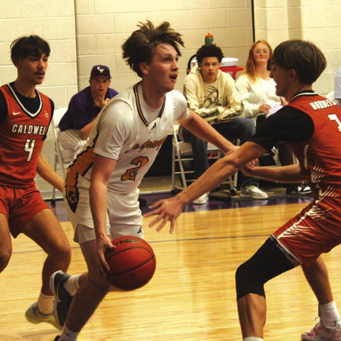 Varsity call-up Caleb Norwood, a sophomore, drives between a pair of Caldwell players Friday. Photo by Jeff Wick