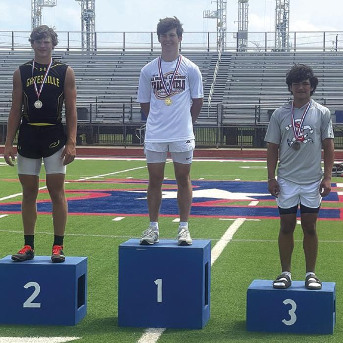 La Grange’s Cordale Knapik stands atop the medal stand in Bullard after winning the regional pole vault title Friday.
