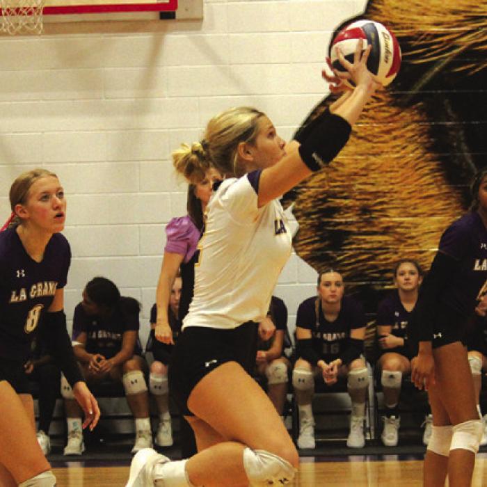 La Grange’s Ashtyn Smith pops up a ball as Carley Ulrich, right, and Brion Williams look on Friday.