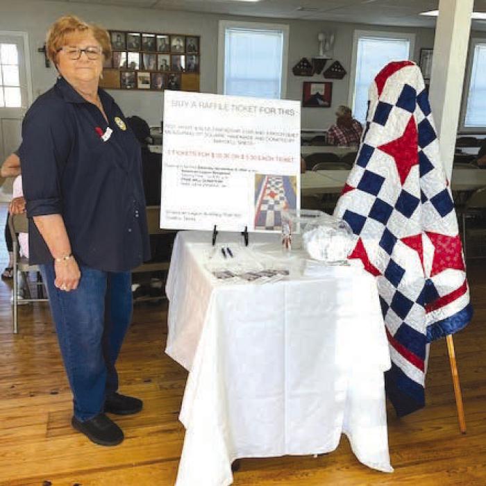Sheila Coufal with Maydell Spiess’ Auxiliary quilt at the American Legion Post 602.