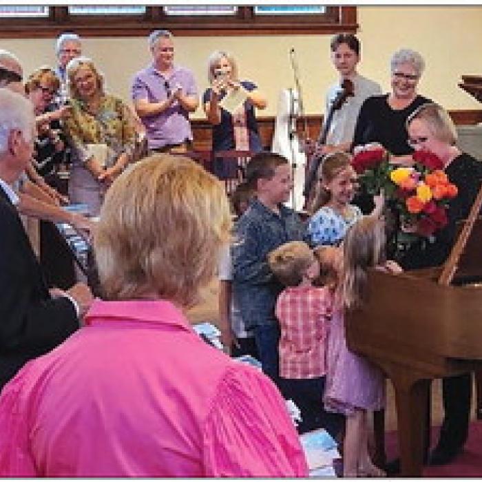 Mary Ann Hatfield’s grandchildren present her flowers after the concert.