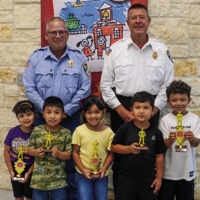 Fire poster winners from the Pre-K and Kindergarten class at La Grange Elementary are (front, from left) Victoria Gugjardo-winner, Leonardo Rodriguez-honorable mention, Analia Mata-winner, Ivan Reveles-honorable mention, and Izaiah Luna-winner. Also pictured are Captain Kenneth Chovanec and Fire Chief Frank Menefee of the La Grange Volunteer Fire Department.
