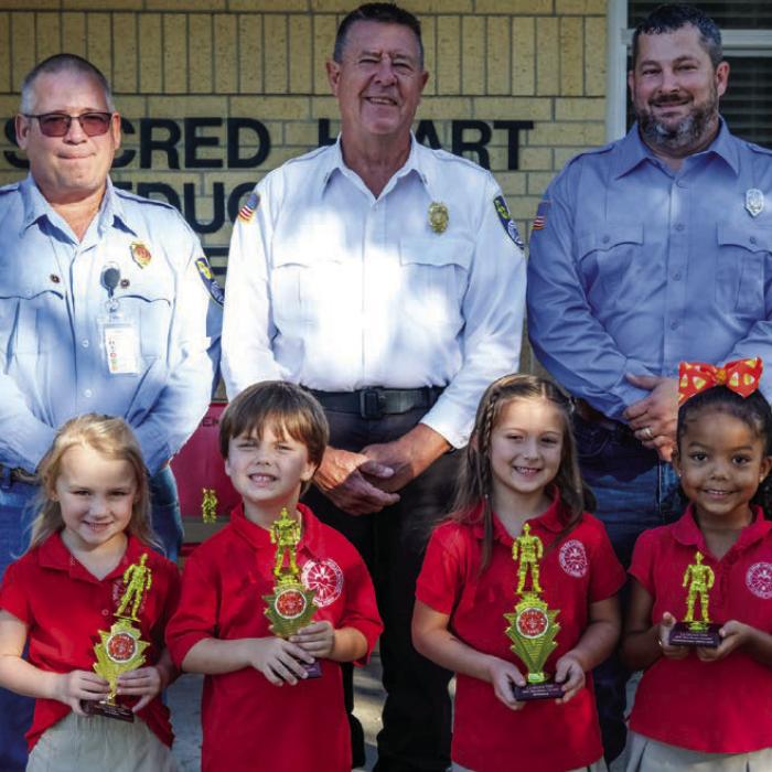 Fire poster winners from the Pre-K and Kindergarten class at Sacred Heart School in La Grange were (front, from left) Adelyn Montgomery, David John Wick, and Madeline Gulash. Honorable mention awards went to Adynn Brown. Also pictured are (back) Captain Kenneth Chovanec, Fire Chief Frank Menefee and Fireman Chris Kaspar of the La Grange Volunteer Fire Department.
