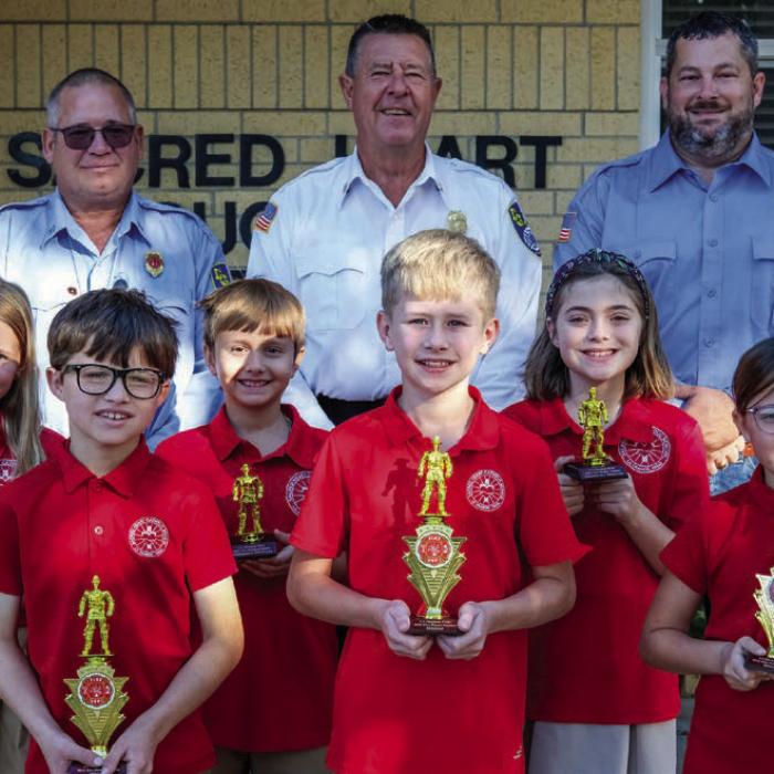 Fire poster winners from the third and fourth grade class at Sacred Heart School in La Grange were (front, from left) Cole Hodges, Blake Markwardt and Macy Hodges. Honorable mention winners were (middle row) Nova Wennermark, Adam Bertsch and Sylvia Shimek. Also pictured are (back) Captain Kenneth Chovanec, Fire Chief Frank Menefee and Fireman Chris Kaspar of the La Grange Volunteer Fire Department.