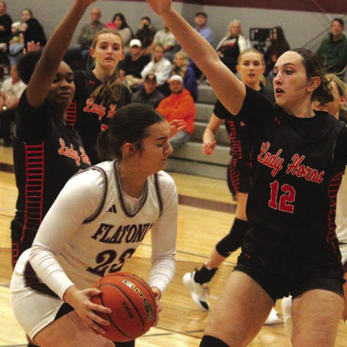 Flatonia’s Abbie Uzzell tries to work her way past the defense of Schulenburg’s Jashiya Jackson, left, and Grace Schramek, right. Photo by Jeff Wick