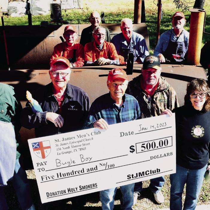 The Holy Smokers January cook benefited the Bugle Boy. Pictured (back, from left) are: Chuck Gibson, Guy Mason, Paul Cheatham, Bill Bailey, Larry Kahanek, and Ed Dykes, (front) Paul Crane, Weldon Koenig, Dan Boyles, Mike Parrish, and Heather Allbright, Executive Director of The Bugle Boy.