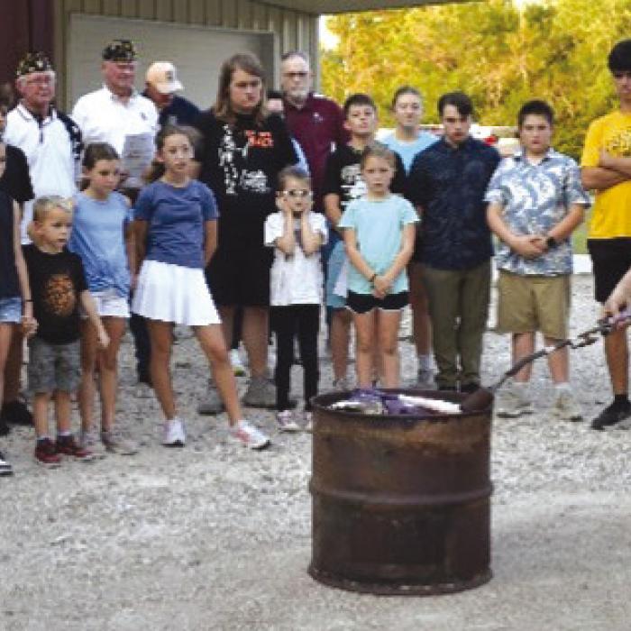 American Legion Post #338 with assistance for Carmine 4H students dispose of an American Flag as part of the Flag Disposal Ceremony held in association with the Carmine Chamber of Commerce Night Out on Oct. 2.