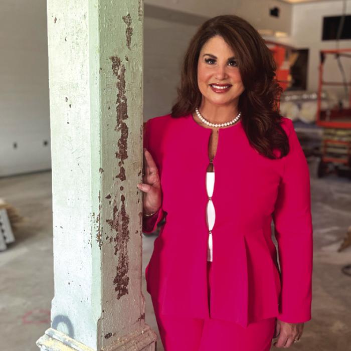 Newly appointed Executive Director Dr. Crystal Gully, in the soon to be completed Phase I of the Fayetteville Community Center &amp; Performance Theater, stands next to one of the reused columns from the original E.J. Knesek Building.