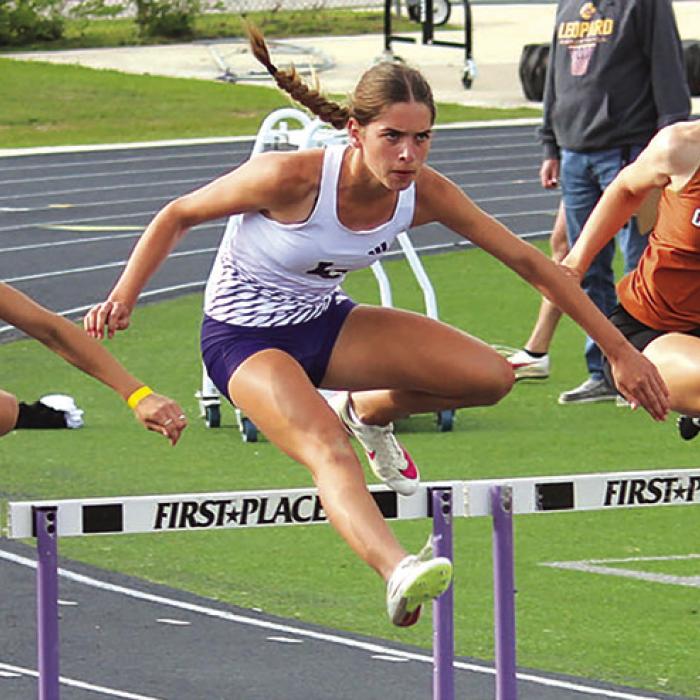 Macie Collier running the 100 hurdles at the area meet. Photo by Jeff Wick