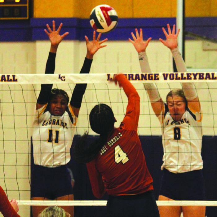 La Grange’s Brion Williams, left, and Carley Ulrich, right, jump to try to block this Caldwell hit Friday. Photo by Jeff Wick