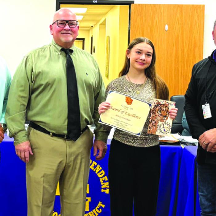 Brinley Freedman, a 9th grader at La Grange High School was recognized at Monday night’s school board meeting for her Christmas card design. She is pictured here with principal-Dr. John Pineda, chool board president-Gary Drab, and superintendent-