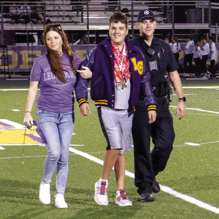 La Grange High School awarded Special Olympics athlete Dylan Haynie with a letterman jacket before the football game Friday night. Haynie competes in bowling and track and field. He is pictured here with his parents Jennifer and Steven Haynie. Photo by Andy Behlen