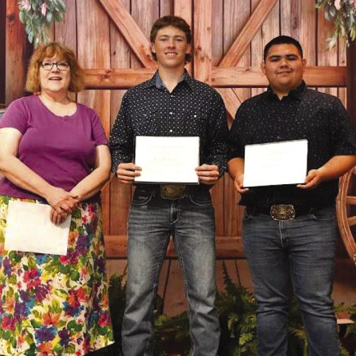 Weimar High School students Troy Cantwell (middle) and Ruben Garcia (right) receive the Friends of KBMH scholarship award for 2025-2026, presented by Katy Beauford (left).