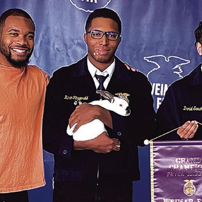 La Grange native and NFL running back J.K. Dobbins bought the grand champion rabbit for $5,000 at the Weimar Junior Livestock Shown earlier this month. Dobbins is shown here, left, with Kance Fitzgerald, center, who exhibited the grand champion fryer rabbit.