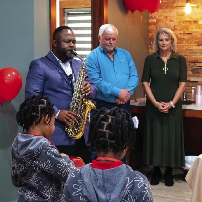 Kenneth Omoruyi plays the National Anthem on his saxophone during the grand opening celebration.