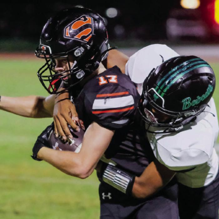 Schulenburg’s Caden Herzik fights for yardage with a Bobcat on his back after catching a pass in the fourth quarter. Photo by Andy Behlen