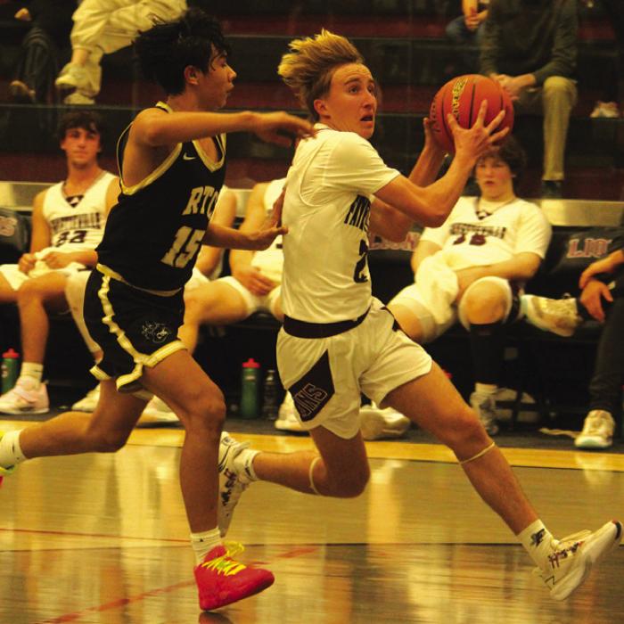 Fayetteville’s Kole Schmitt drives to the basket in Friday’s game as Round Top-Carmine’s Facundo Cerda is right on his heels. Photo by Jeff Wick