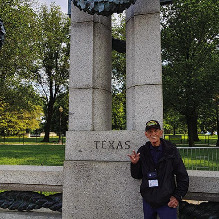 Brown throws up a “Hook ‘em Horns” gesture in front of the Texas monument at the World War II Memorial.
