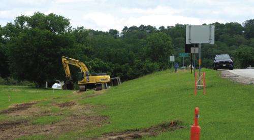 Folks in La Grange have probably noticed the large excavator near the Colorado River Bridge on U.S. 77. City Manager Jack Thompson said the machine is being used to install some large box culverts that are part of the City stormwater drainage improvement project. Photo by Andy Behlen
