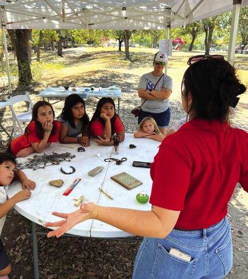 Educator Railey Tassin uses interpretation techniques with students at Archeology Day.