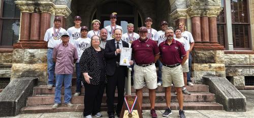 Members and Coaches of the Flatonia high school baseball team were honored on the steps of the Courthouse on Wednesday, July 24, 2024. Coaches Shawn Bruns and Mark Migl and their team were given a proclamation signed by County Judge Dan Mueller and County Attorney Peggy Supak. Also pictured is Gary Dusek of KVLG KBUK the voice of the Bulldogs.