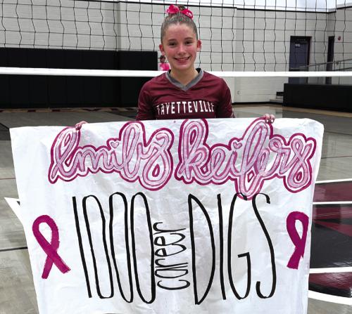 Fayetteville junior Emily Keilers holds up a banner after recording her 1,000th career dig at a recent match.