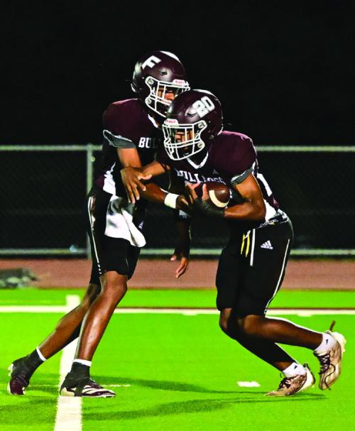 Quarterback Jaylon Anderson hands off to Adrian Anderson Friday night in Flatonia. The Flatonia Bulldogs beat the Three Rivers Bulldogs in a non district game Friday night. The Bulldogs will begin district action this Friday in Flatonia when they host Ganado. Photo by Stephanie Steinhauser