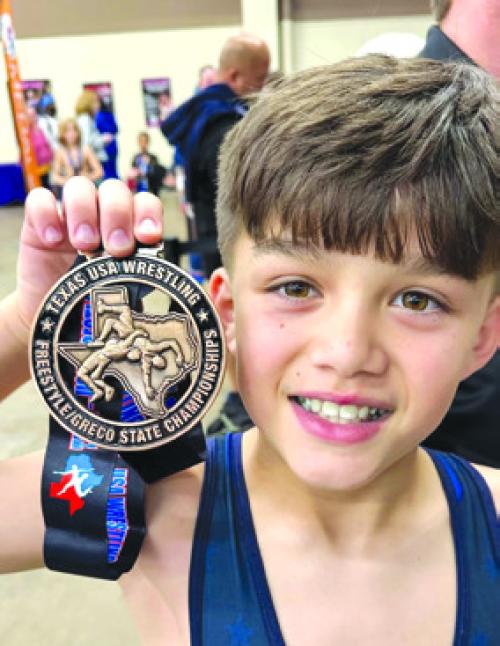 Kathy and Frank Chlumsky’s grandson Hunter Dong with his 3rd place state metal.