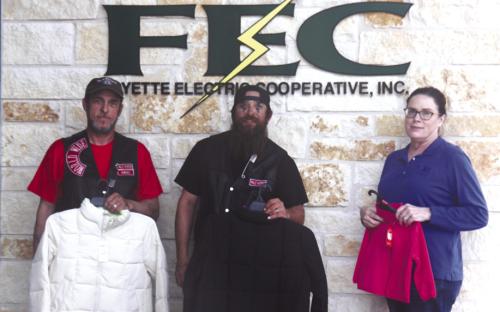 Palehorse Motorcycle Club President John Sturrock, Vice President James Risinger, and FEC Director of Marketing, Training, and Communication Tracy Denton display coats donated to FEC’s Coat Connection coat drive, highlighting the strength of community collaboration.
