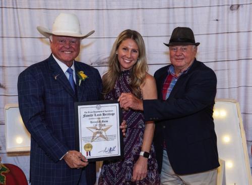 Bob Heinrich and daughter Stacey Heinrich Smatresk accept the Texas Department of Agriculture Family Land Heritage Certificate marking 150 years of continuous agriculture production on the Heinrich Farm near Schulenburg. Presenting the award is Texas Agriculture Commissioner Sid Miller.