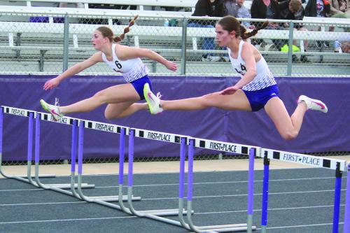 La Grange’s Macie Collier, right, and Campbell Cooper, left, battle for the lead midway through the 100 meter hurdles at the Leopard Relays Thursday. Collier won and Campbell was second. They repeated that finish in the 300 meter hurdles later in the night. Photo by Jeff Wick