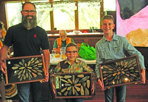 Jeremy Janda and his sons Reed and Will of La Grange, hold up some of the display cases of arrowheads they brought to the La Grange Noon Lions Club Thursday for a talk about how they find these artifacts. Photo by Jeff Wick