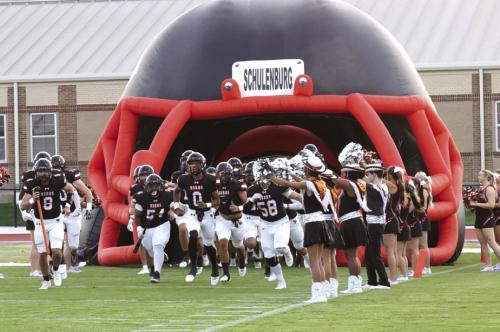 The Schulenburg football team runs out of its pregame tunnel at the start of the game two weeks ago against Rogers. Photo by Audrey Kristynik