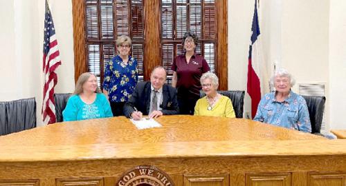 Shown at the proclamation signing (from left): seated, Donna Burton, Judge Dan Mueller, Lila Garlin, Jeanette Huelsebusch; standing, Sally Garrett, County Extension Agent-FCH and Jenifer Boening, County Program Assistant-FCH.