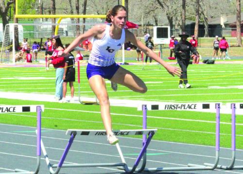 Macie Collier goes over the final hurdle of the 300 meter hurdles last Friday with no one else in sight to win the event. Photo by Jeff Wick