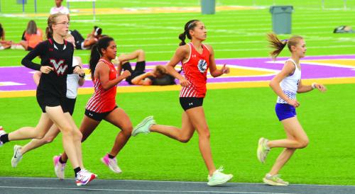 La Grange’s Lilian Carey leads the pack in the early stages of the varsity 3200 meters Thursday. She was second with a time of 12:42.81 Photo by Jeff Wick