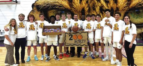 La Grange head boys basketball coach Trent Collier, center, holding the basketball, is shown here after Tuesday’s career victory #200 victory, celebrating with his varsity team, assistant coaches and family. Photo by Jeff Wick