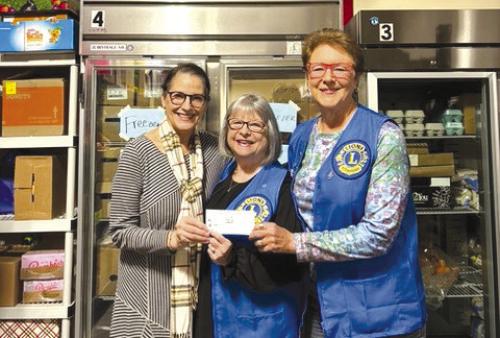 Fayetteville Lions Club president Linda Hudson donating funds to the AMEN Food Pantry.