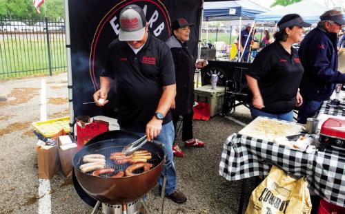 Tracy Ebarb of Ebarb Craft Sausage grills some of his company’s famous links at their booth during last year’s Sausagefest. Record File Photo