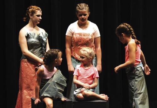 Mermaids (from left), back, Megan Pleger, Mattie Muzny, Alice Muzny and front, Bailey Tousek, and Lucy Martin, all gather round to adjust costumes and pose for a program photo.