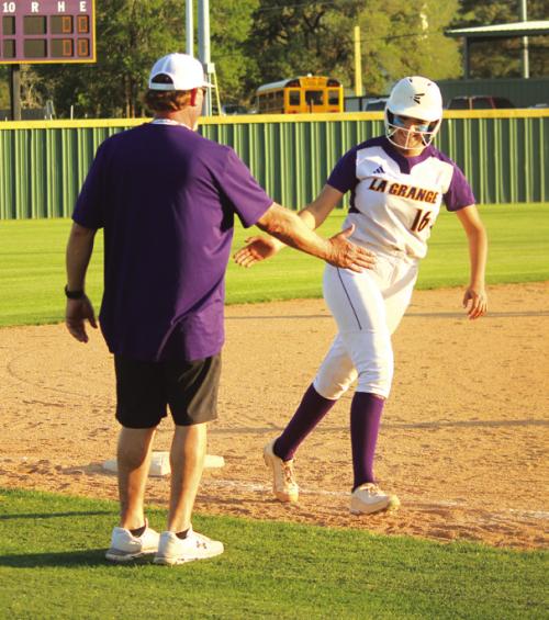As La Grange’s Melissa Gonzales trots around third base after her home run Tuesday, she gets a high-five from La Grange softball coach Robert Young. Photos by Jeff Wick