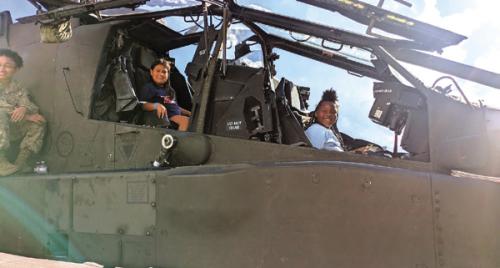 The local girls who attended Aviation Day at the Lone Star Flight Museum in Houston got to climb in a helicopter, above, and asked questions at a panel discussion, below.