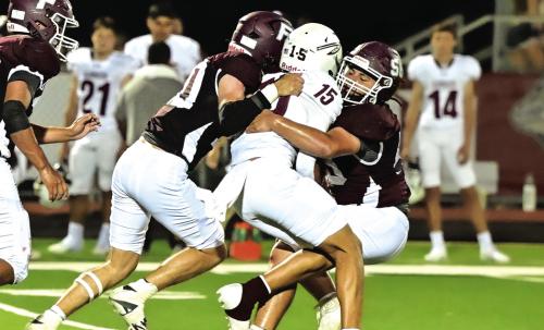 Eli Kubesch (#10) and Gabriel Aguillion (#56) take down the Ganado quarterback Friday night in district opener. The Bulldogs fell to the The Indians and will hit the road to Bloomington this week. Photo by Stephanie Steinhauser