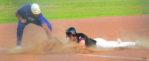 In a cloud of dust, Schulenburg’s Reid Janda slides safely into third base in Tuesday’s victory. Photo by Jeff Wick