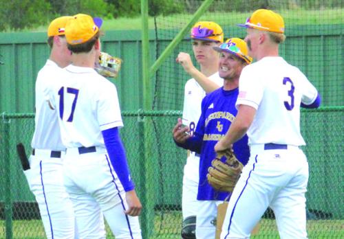 La Grange head coach James Zaruba, in purple, is all smiles as he talks to his players between innings earlier this season.